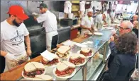  ?? ASSOCIATED PRESS ?? Orders are ready to go out at Katz’s Delicatess­en in New York. The restaurant is launching an expanded global delivery business that will allow people to ship its cured meats around the world.
