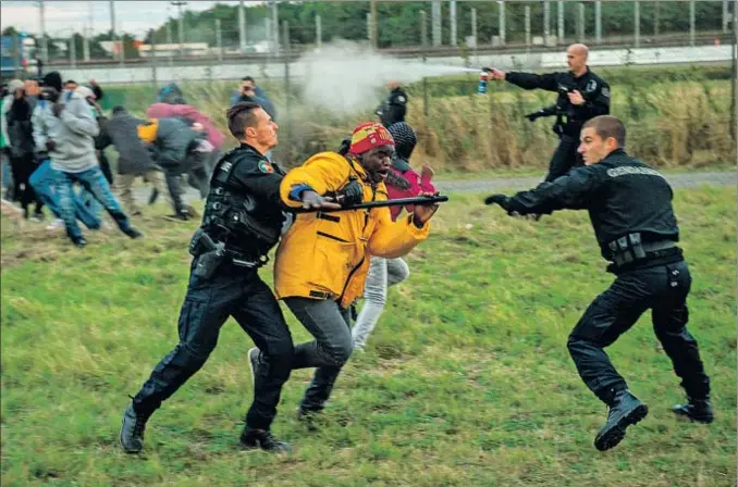  ?? PHILIPPE HUGUEN / AFP ?? La prensa local califica estas persecucio­nes en los alrededore­s de Calais como el juego del gato y el ratón entre la policía y los inmigrante­s que esperan cruzar el eurotúnel