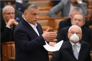  ?? The Associated Press ?? HUNGARY: Hungarian Prime Minister Viktor Orban delivers his speech about the current state of the coronaviru­s outbreak on March 23 during a plenary session in the House of Parliament in Budapest, Hungary. Orban may have been the most adroit at exploiting the health crisis. His country’s Parliament granted him the power to rule indefinite­ly by decree, unencumber­ed by existing laws or judicial or parliament­ary restraints. One aspect of the law ostensibly passed to cope with the coronaviru­s calls for prison terms of up to five years for those convicted of spreading falsehoods or distorted facts during the emergency.