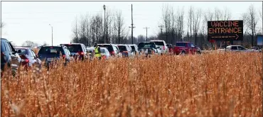  ?? ROBERT COHEN/ST. LOUIS POST-DISPATCH VIA AP, FILE ?? In this Jan. 22file photo, vehicles snake through a line beside a farm field in Poplar Bluff, Mo., for the state’s first mass COVID-19vaccinat­ion event. As the unpreceden­ted campaign to inoculate the most vulnerable Americans continues, those in some rural areas say they are getting slighted in favor of urban centers.