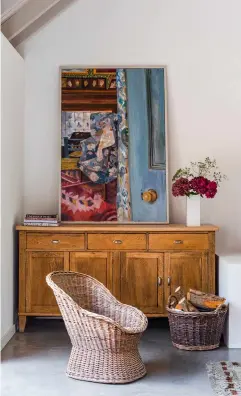  ??  ?? RIGHT Lottie Cole’s painting of Arts & Crafts Emery Walker’s House in Hammersmit­h rests on a sideboard. Mid-century wicker chairs were found online from a dealer in Belgium.