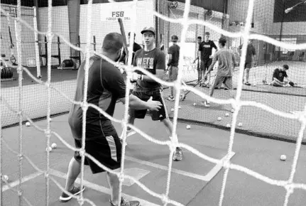  ?? DAVID WHITLEY/STAFF ?? Instructor is Mike Mercadente works with student Gabriel Ferrer at TXNL Baseball Academy in Altamonte Springs.