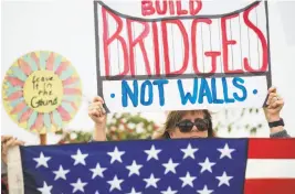  ?? Kyusung Gong / Associated Press ?? Lauren Rees hoists her sign overhead in a protest against Trump, who visited San Diego before heading for a Los Angeles-area fundraiser.