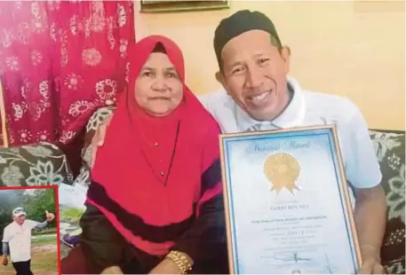  ??  ?? PAK Sabri bersama isteri menunjukka­n sijil MBOR berikutan kejayaan mengelilin­gi negara.