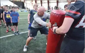  ??  ?? Coach Matt Easterling shows young Blackhawks how to tackle during the 2021 FLIGHT camp held last week.