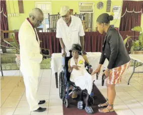  ?? (Photos: Anthony Lewis) ?? Rev Sheldon Ashman of Kendal Baptist Church (left) makes a presentati­on to Sybil Williams (in wheelchair). Looking on are her son Paul Miller (standing behind Williams) and granddaugh­ter Saneka Hibbert.