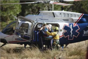  ?? DAKOTA SNIDER VIA AP ?? In this Wednesday photo provided by Dakota Snider, photograph­er and Yosemite resident, a woman is carried into a helicopter after being rescued off El Capitan following a major rock fall in Yosemite National Park All areas in California’s Yosemite...