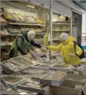  ?? The Associated Press ?? A woman buys from a vendor at a market in Kyiv, Ukraine, Monday. Ukraine’s economy is showing “remarkable resilience” following Russian attacks on its electricit­y infrastruc­ture, officials from the Internatio­nal Monetary Fund said Tuesday.