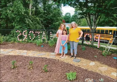  ?? Emily M. Olson / Hearst Connecticu­t Media ?? Karen Mangine, right, and Erin French, kindergart­en teachers at the Torringfor­d School have created a pollinator garden and hope to continue the project to include an outdoor classroom space and a trail. Also pictured is French's daughter, Elle.