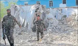  ?? AP ?? Security forces inspect an explosion site in Lashkar Gah, capital of southern Helmand province.