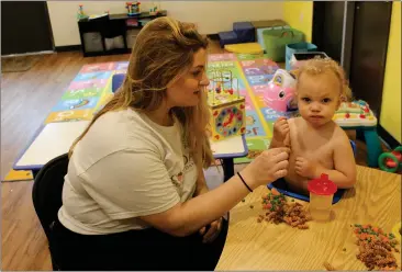  ?? PHOTOS BY ED BOOTH — ENTERPRISE-RECORD ?? Paul Metzen, 22months, enjoys a midmorning snack at Acorns to Oaks Preschool and Daycare while infants attendant Rachael Kitts looks on Tuesday in Chico.