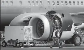  ?? AP/TED S. WARREN ?? A worker walks past an engine of a Boeing 737 MAX 8 airplane being built last week for American Airlines at Boeing Co.’s assembly plant in Renton, Wash.