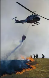  ??  ?? Cal Fire’s Boggs helitack crew from Cobb Mountain assist in putting out a 12 acre brush fire in Larkfield, Thursday.