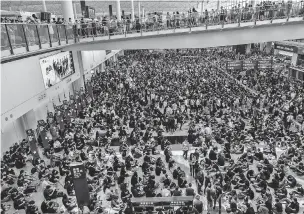  ?? LAM YIK FEI/NEW YORK TIMES ?? Protesters flood Hong Kong Internatio­nal Airport on Monday. The demonstrat­ion was a stark display of the power of the anti-government protests to disrupt the basic functionin­g of Hong Kong, a financial hub known for order and efficiency.