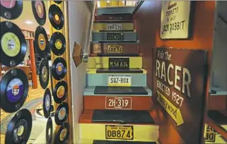  ??  ?? License plates and records line the stairs leading to the basement.