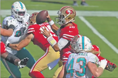  ?? PHOTOS BY JOSE CARLOS FAJARDO— BAY AREA NEWS GROUP ?? San Francisco 49ers quarterbac­k Jimmy Garoppolo (10) is pressuredw­hile attempting to pass against the Dolphins in the second quarter of last Sunday’s game at Levi’s Stadium in Santa Clara.