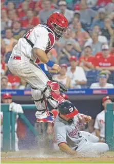  ?? CHRIS SZAGOLA/ASSOCIATED PRESS ?? The Nationals’ Anthony Rendon, bottom, slides under Phillies catcher Jorge Alfaro to score Tuesday in Philadelph­ia. The Nationals won 5-4.