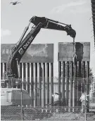  ?? Herika Martinez / AFP/Getty Images ?? Workers in El Paso replace a section of the Mexico-U.S. border fence next to the internatio­nal border bridge.