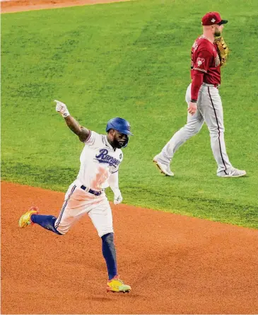  ?? Tony Gutierrez/Associated Press ?? Rangers outfielder Adolis García crushed a walk-off home run in the 11th inning to lift Texas to a 6-5 win over the Diamondbac­ks and bring his RBI total in the playoffs to 22, the most ever in one postseason.