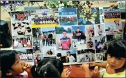  ?? REUTERS ?? Children look at pictures as relatives and friends pray for the 12 schoolboys and their soccer coach trapped in a flooded cave, at a church in Chiang Rai, Thailand, on Sunday.