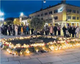  ?? TERJE BENDIKSBY/NTB SCANPIX ?? Flowers and candles are placed Thursday at the scene of an deadly attack Wednesday in Kongsberg, Norway. A Danish national is in custody.