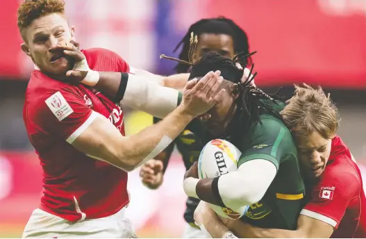  ?? DARRYL DYCK/THE CANADIAN PRESS FILES ?? Canada's Connor Braid, left, and Harry Jones, right, tackle South Africa's Branco du Preez when the Sevens tour came to Vancouver in March 2020.