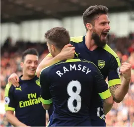  ??  ?? Olivier Giroud celebrates with Aaron Ramsey after netting the fourth goal of the night for Arsenal as they look to secure a Champions League spot late on