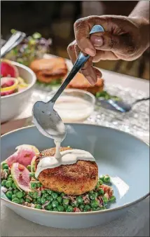  ?? COURTESY OF NOAH FECKS ?? Buttermilk Dressing is drizzled onto Fresh Salmon Croquettes With Spring Pea, Bacon, and Radish Salad in this image from “The Twisted Soul Cookbook: Modern Soul Food With Global Flavors,” Rizzoli New York, 2021) by Deborah Vantrece.