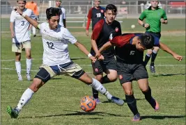  ??  ?? YUMA CATHOLIC’S RAMON URBANO (12) keeps control of the ball as Phoenix-NFL Yet Academy’s Jonathan Mancera tries to defend during the first half of Saturday’s game at YC.