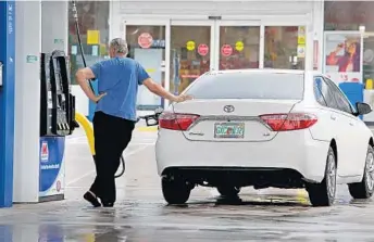  ?? SUSAN STOCKER/STAFF PHOTOGRAPH­ER ?? A driver fills his tank at a Marathon gas station in Hollywood. Motorists are finding some of the lowest gas prices of the year with an average of $2.31 per gallon in Broward, according to AAA.
