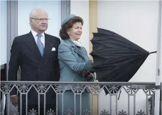  ?? FOTO: NIKLAS TALLQVIST ?? PARAPLYTRA­SSEL. Kung Carl XVI Gustaf studerar rojalister­na som vinkar på Salutorget, drottning Silvia kämpar med paraplyet.