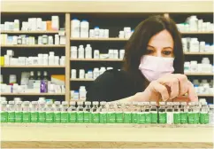  ?? NATHAN DENETTE / THE CANADIAN PRESS FILES ?? Toronto pharmacist Barbara Violo arranges empty vials
of Astrazenec­a vaccine in April.