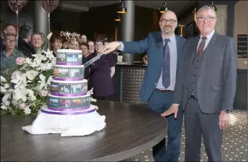  ??  ?? Colm Neville, proprietor, cutting the cake with general manager Jim Maher, to mark the 20th anniversar­y of the Riverside Park Hotel.