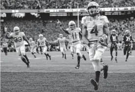  ?? Adam Hunger/associated Press ?? Army quarterbac­k Christian Anderson celebrates after scoring a touchdown against Navy during last year’s game in Philadelph­ia.