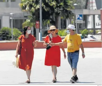  ?? M.C.I.C. ?? Tres personas pasean por La Línea de la Concepción.