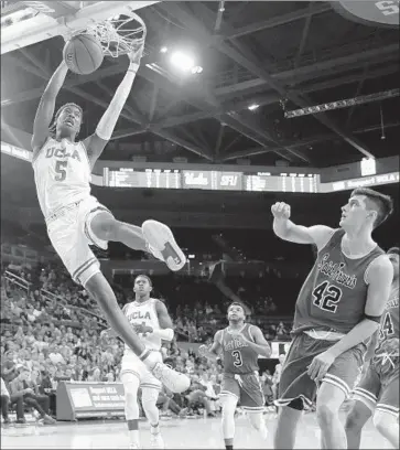  ?? Marcio Jose Sanchez Associated Press ?? UCLA GUARD Chris Smith dunks past St. Francis forward Mark Flagg (42) during the second half of Friday’s 95-58 win. In the game, the Bruins outscored St. Francis by 30 points in the second half.