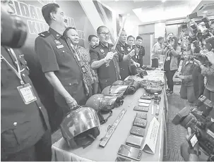  ?? — Gambar Bernama ?? RAMPASAN: Mazlan Lazim (tiga, kiri) menunjukka­n barang rampasan kepada pemberita pada Sidang Media Ketua Polis Kuala Lumpur berkaitan kejayaan membantera­s kes ragut di Ibu Pejabat Kuala Lumpur (IPK) semalam.