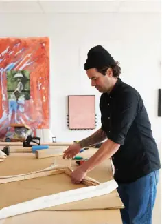  ??  ?? TOP Posterior ll, 2019, made with found jute fabric in a hand-carved wooden frame. ABOVE RIGHT Tom’s been in this studio for a year and loves its central location and natural light. Here, he’s stretching canvas on his work table. The artwork on the left of the wall behind him is Hands & Knees by Mary Teague, an Australian artist whose work he was introduced to by a friend. He says, “It’s a luxury to be surrounded by great artworks every day that inspire me to think and create.“