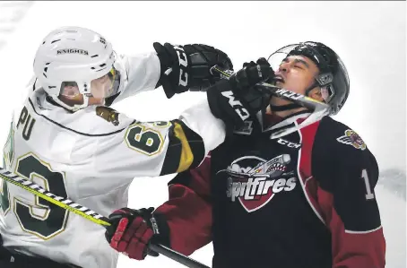  ?? PHOTOS: JASON KRYK ?? The London Knights Cliff Pu gets his stick up on the Spitfires’ Adam Laishram during Tuesday’s Game 3 of their West Conference quarter-final game. The Spitfires take a 2-1 lead into Thursday night’s Game 4 at WFCU Centre.