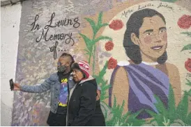  ?? ANTHONY VAZQUEZ/ SUN- TIMES ?? Cletora Kirkman takes a picture with a family member at a mural honoring her mother, Myrtis Jackson, in Gresham on Wednesday.