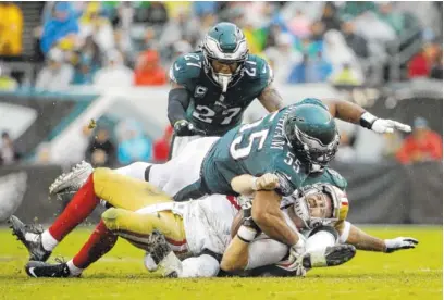  ?? THE ASSOCIATED PRESS ?? The San Francisco 49ers’ C.J. Beathard is sacked by the Philadelph­ia Eagles’ Brandon Graham (55) and Mychal Kendricks as Malcolm Jenkins (27) looks on during a game Oct. 29 in Philadelph­ia.