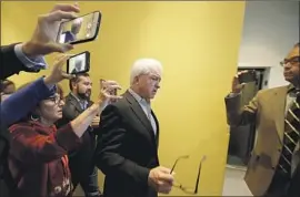  ??  ?? REPUBLICAN candidate John Cox, center, walks while speaking with reporters after the debate at the KQED radio studio in San Francisco.