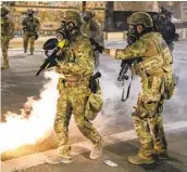  ?? DAVE KILLEN AP ?? Police respond to protesters Friday in Portland, Ore. Militarize­d federal agents deployed by the president to Portland fired tear gas against protesters.