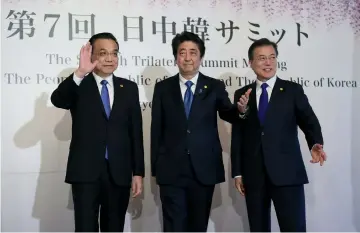  ??  ?? (From left) Li Keqiang, Shinzo Abe and Moon Jae-in pose for photograph­ers prior to their summit in Tokyo. — Reuters photo