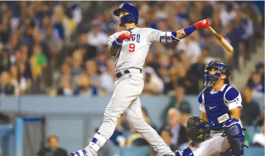  ?? GETTY IMAGES ?? Javy Baez follows through on his grand slam — his second home run of the game — during the Cubs’ six- run sixth inning Tuesday against the Dodgers.