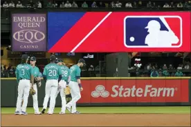  ?? THE ASSOCIATED PRESS FILE ?? Mariners gather as the MLB logo is shown during a review of an attempted catch by right fielder Mitch Haniger of a ball hit by Rays’ Ji-Man Choi that was originally called an out during the ninth inning of a game Friday, June 18, 2021, in Seattle.