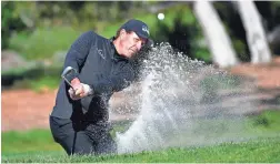  ??  ?? Phil Mickelson hits out of the bunker on the second hole during the final round of the AT&T Pebble Beach Pro-Am on Sunday at Pebble Beach Golf Links.