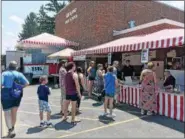  ?? BILL DEBUS — THE NEWS-HERALD ?? The vending booth serving up treats featuring fresh strawberri­es is a busy place on June 17 at the Kirtland Kiwanis Strawberry Festival.