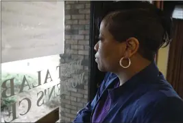  ?? ALLEN G. BREED — THE ASSOCIATED PRESS ?? Alesia Horton, director of the West Alabama Women's Center in Tuscaloosa, looks out the window at protesters on Tuesday. A deeply religious woman, she says of those who picket the clinic: “God isn't theirs. God is all of ours.”