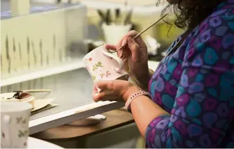  ??  ?? A Wedgwood factory artisan paints the finishing touches.